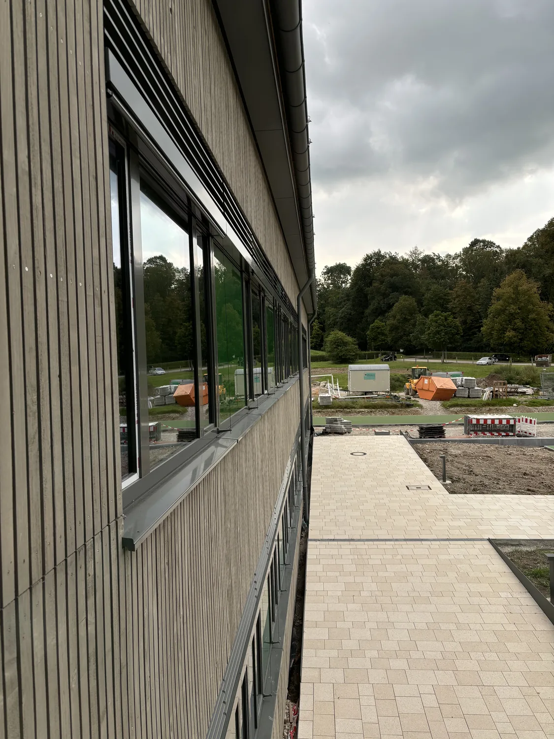 Fensterbänder in der Holzfassade, darüber die Lüftungslamellen