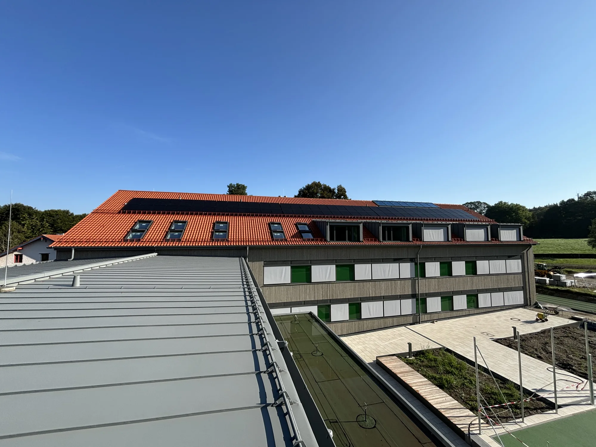 Dachlandschaft aus Stehfalz, Ziegel und Photovoltaik