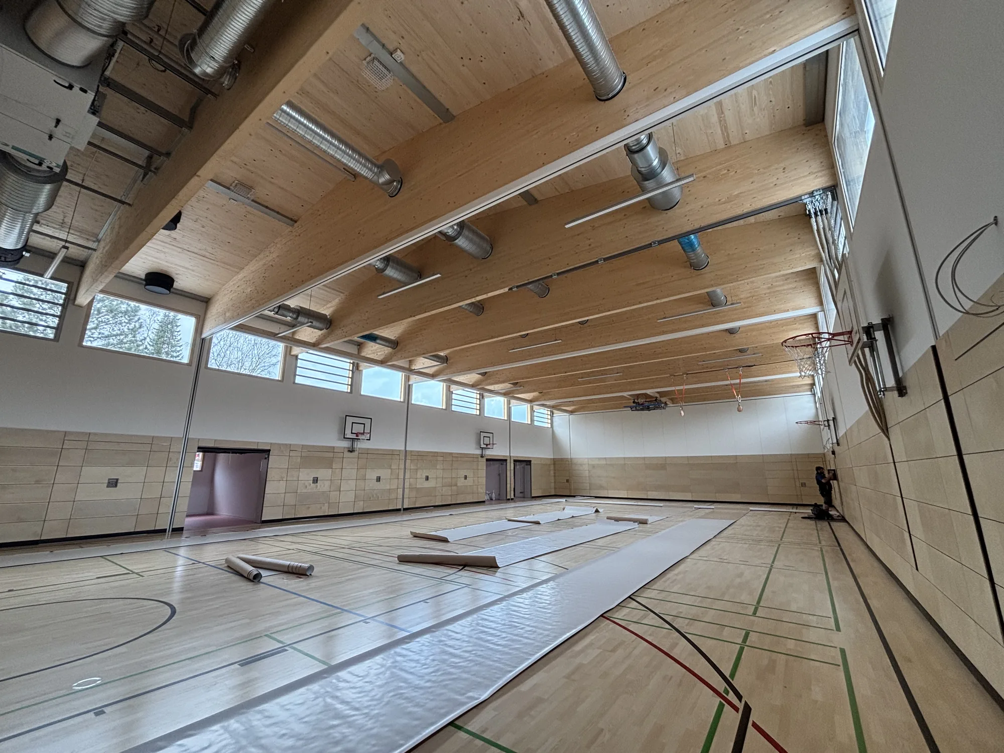 Hallendach aus Brettschichtholz-Bindern, dazwischen die Akustikdecke